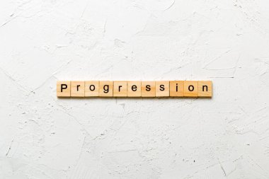 Tahta bloğa yazılmış bir kelime. desing, konsept için beton tablo üzerindeki ilerleme metni.