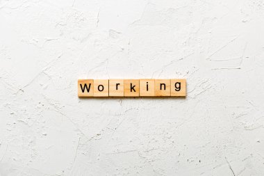 Tahta blokta yazılı bir kelime. Çimento masasında çalışma metni desing, konsept.