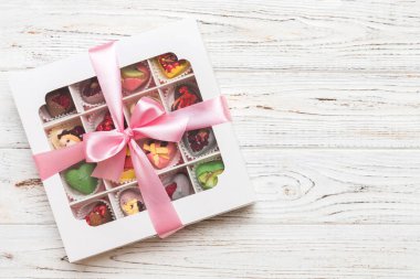 Box with sweet chocolate candies on color background, Various candy sweets. Valentines day gift box. Top view flat lay with copy space.