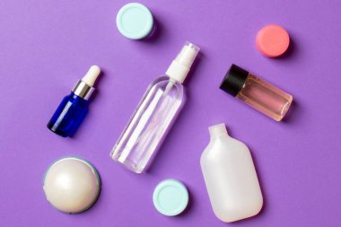 Kozmetik SPA marka modeli, fotokopi alanı olan üst görünüm. Renkli arka planda duran krema tüpleri ve kavanozları..