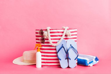 Plaj aksesuarlarıyla süslü bir çanta. Yaz tatili konsepti. Yazmak için alanı olan güneş kremi ile plaj çantasının üst görünümü.