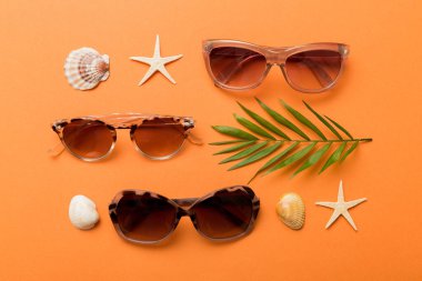 Masa arkasında deniz kabuğu olan güneş gözlükleri. Yaz arkaplanında güneş gözlüğü. Metin için kopyalama alanı olan üst görünüm düzlüğü.