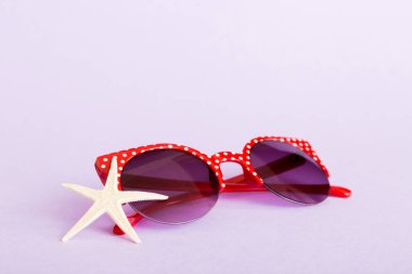 Masa arkasında deniz kabuğu olan güneş gözlükleri. Yaz arkaplanında güneş gözlüğü. Metin için kopyalama alanı olan üst görünüm düzlüğü.