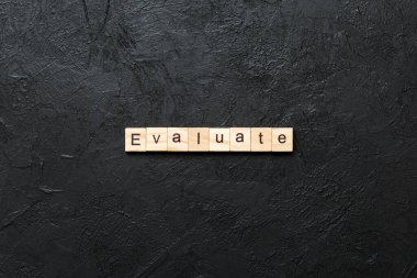 Tahta blokta yazan kelimeyi değerlendir. Deksing, konsept için çimento masadaki metni değerlendir.