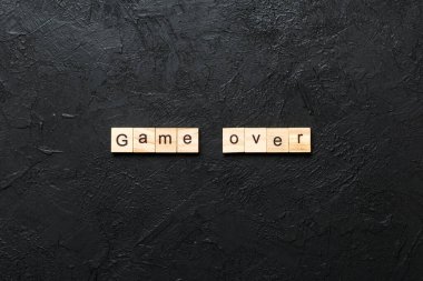 Tahta blokta yazılı oyun bitti. Masada oyun üzeri metin, konsept.