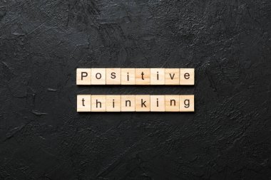 Tahta bloğa yazılmış pozitif düşünce kelimesi. Masada olumlu düşünce metni, konsept.