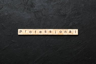 Ahşap bloğa yazılmış profesyonel bir kelime. Desing, konsept için çimento masadaki profesyonel metin.