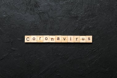 Tahta blokta Coronavirus kelimesi yazılı. Masada coronavirus metni, konsept.