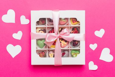 Valentine day composition: sweet candy, with gift boxes with bow and red felt hearts, photo template, background. Top View with copy space.
