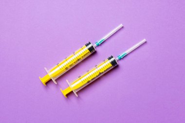 Renkli arka planda fotokopi alanı olan tıbbi şırıngaların üst görüntüsü. Enjeksiyon ekipmanı konsepti.