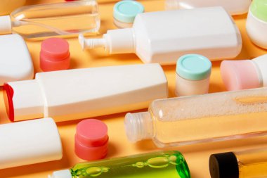 Plastik gövde bakımı şişesi düz kompozisyonu ve renkli arka plan boşluğuna kozmetik ürünler dizayn edilmişti. Beyaz Kozmetik kapları kümesi, kopya alanı ile üst görünüm.