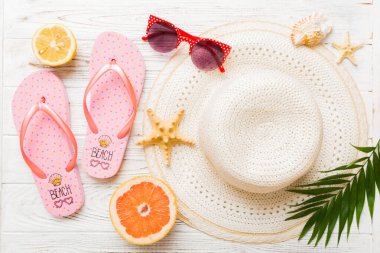Renkli meyvelerin yanına yerleştirilmiş çeşitli deniz kabuklarının üst görüntüsü ve masa arkasında şık yaz aksesuarları. Yaz kavramı. Düz yatıyordu. Metin için kopyalama alanı olan üst görünüm.
