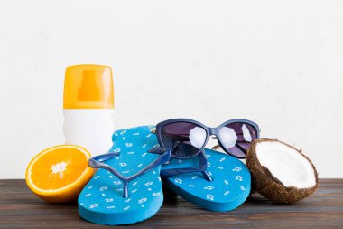 Plaj aksesuarları perspektifli terliklerin masa arkasına yerleştirilmiş üst görünüm kompozisyonu. Tropik yaz tatili konsepti.