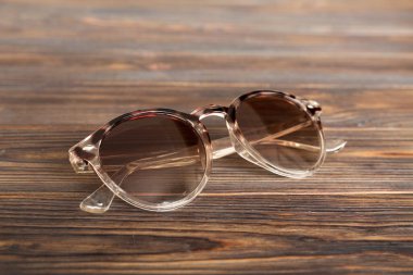 Masa arkasında deniz kabuğu olan güneş gözlükleri. Yaz arkaplanında güneş gözlüğü. Metin için kopyalama alanı olan üst görünüm düzlüğü.