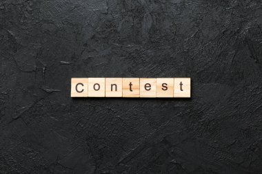 Tahta blokta yazan yarışma kelimesi. Üst görünüm konseptiniz için çimento tablosunda yarışma metni.