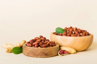 Fresh healthy peanuts in bowl on colored table background. Top view Healthy eating bertholletia concept. Super foods.