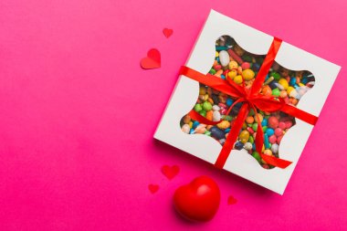Valentine day composition: sweet candy, with gift boxes with bow and red felt hearts, photo template, background. Top View with copy space.