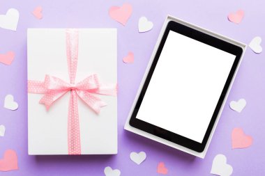 Gift box of open tablet for the holidays with a bow top view.