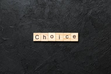 Tahta bloğa yazılmış bir kelime. Deksing, konsept için çimento masadaki CHOICE metni.
