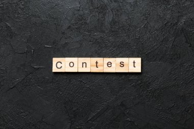 Tahta blokta yazan yarışma kelimesi. Üst görünüm konseptiniz için çimento tablosunda yarışma metni.