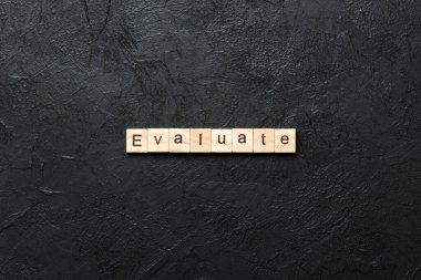 Tahta blokta yazan kelimeyi değerlendir. Deksing, konsept için çimento masadaki metni değerlendir.