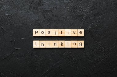 Tahta bloğa yazılmış pozitif düşünce kelimesi. Masada olumlu düşünce metni, konsept.