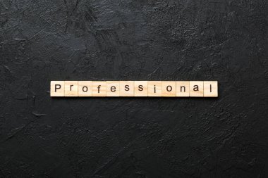 Ahşap bloğa yazılmış profesyonel bir kelime. Desing, konsept için çimento masadaki profesyonel metin.