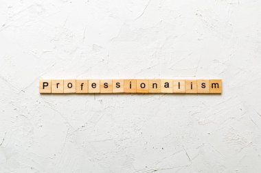 Ahşap blokta yazan profesyonellik kelimesi. Desing, konsept için çimento masadaki profesyonellik metni.