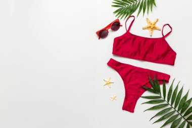 Gezgin aksesuarları, kadın yaz bikinileri masa arkasına bikini takımı ve mesaj için boş yer. Seyahat tatili konsepti. Düz yatıyordu, üst görünüm, seksi mayo..