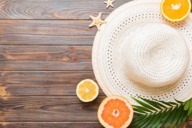 Renkli meyvelerin yanına yerleştirilmiş çeşitli deniz kabuklarının üst görüntüsü ve masa arkasında şık yaz aksesuarları. Yaz kavramı. Düz yatıyordu. Metin için kopyalama alanı olan üst görünüm.