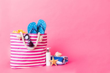 Plaj aksesuarlarıyla süslü bir çanta. Yaz tatili konsepti. Yazmak için alanı olan güneş kremi ile plaj çantasının üst görünümü.