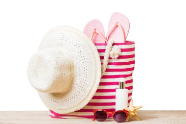 Plaj aksesuarlarıyla süslü bir çanta. Yaz tatili konsepti. Yazmak için alanı olan güneş kremi ile plaj çantasının üst görünümü.