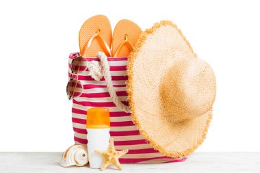 Plaj aksesuarlarıyla süslü bir çanta. Yaz tatili konsepti. Yazmak için alanı olan güneş kremi ile plaj çantasının üst görünümü.