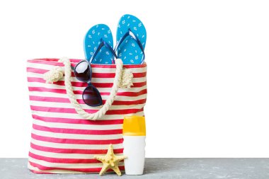 Plaj aksesuarlarıyla süslü bir çanta. Yaz tatili konsepti. Yazmak için alanı olan güneş kremi ile plaj çantasının üst görünümü.