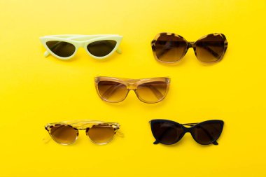 Masa arkasında deniz kabuğu olan güneş gözlükleri. Yaz arkaplanında güneş gözlüğü. Metin için kopyalama alanı olan üst görünüm düzlüğü.