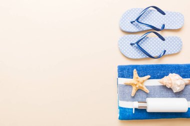 Yaz tatili konsepti. Plaj havlusunun üst görünümü, flop ve güneş kremi Üst görünümü metin için kopyalama alanı.