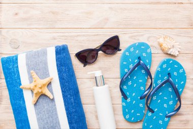 Yaz tatili konsepti. Plaj havlusunun üst görünümü, flop ve güneş kremi Üst görünümü metin için kopyalama alanı.