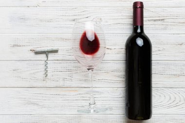 Tirbuşonlu düz kompozisyon, bir şişe şarap ve renkli masada zarif bir cam. Düz konum, üst görünüm kopyalama alanı.