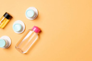 Renkli arka planda seyahat boyutunda kozmetik şişeler. Krema kavanozları düzdü. Vücut bakım stili kavramının en üst görünümü.