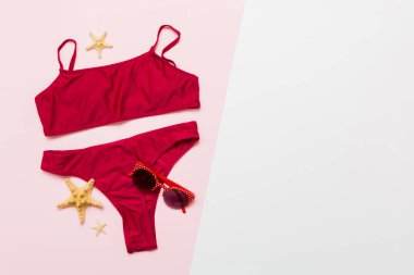 Gezgin aksesuarları, kadın yaz bikinileri masa arkasına bikini takımı ve mesaj için boş yer. Seyahat tatili konsepti. Düz yatıyordu, üst görünüm, seksi mayo..