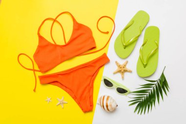 Gezgin aksesuarları, kadın yaz bikinileri masa arkasına bikini takımı ve mesaj için boş yer. Seyahat tatili konsepti. Düz yatıyordu, üst görünüm, seksi mayo..