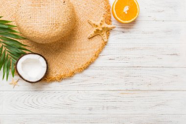 Renkli meyvelerin yanına yerleştirilmiş çeşitli deniz kabuklarının üst görüntüsü ve masa arkasında şık yaz aksesuarları. Yaz kavramı. Düz yatıyordu. Metin için kopyalama alanı olan üst görünüm.