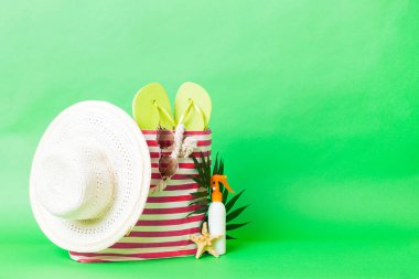 Plaj aksesuarlarıyla süslü bir çanta. Yaz tatili konsepti. Yazmak için alanı olan güneş kremi ile plaj çantasının üst görünümü.