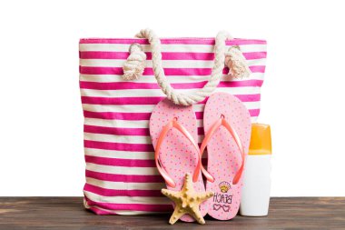 Plaj aksesuarlarıyla süslü bir çanta. Yaz tatili konsepti. Yazmak için alanı olan güneş kremi ile plaj çantasının üst görünümü.