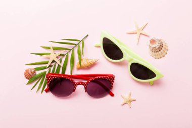Masa arkasında deniz kabuğu olan güneş gözlükleri. Yaz arkaplanında güneş gözlüğü. Metin için kopyalama alanı olan üst görünüm düzlüğü.