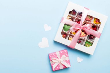 Valentine day composition: sweet candy, with gift boxes with bow and red felt hearts, photo template, background. Top View with copy space.