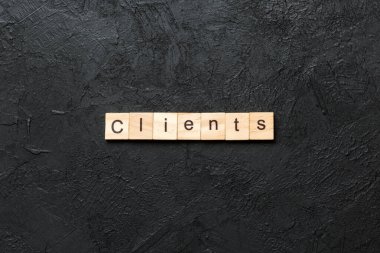 Müşteri sözcüğü ahşap blokta yazılı. Müşteriler masa üzerinde metin, konsept.