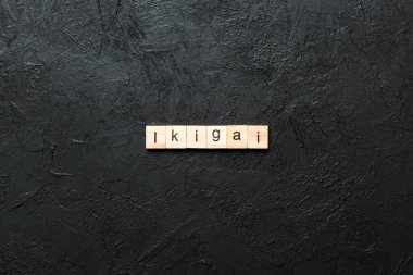 ikigai word written on wood block. ikigai text on table, concept. clipart