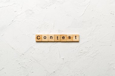 Tahta blokta yazan yarışma kelimesi. Üst görünüm konseptiniz için çimento tablosunda yarışma metni.