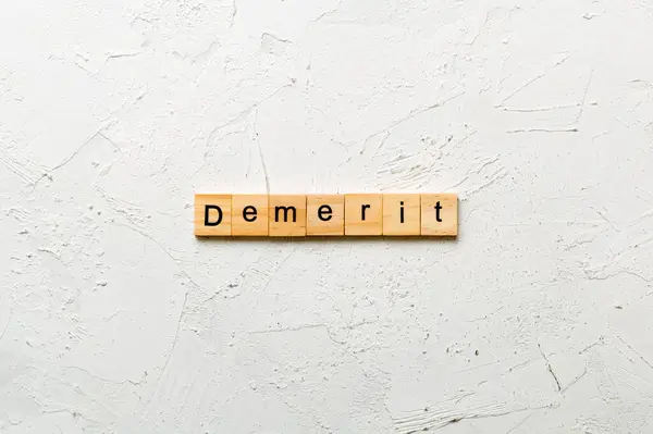 stock image demerit word written on wood block. demerit text on table, concept.